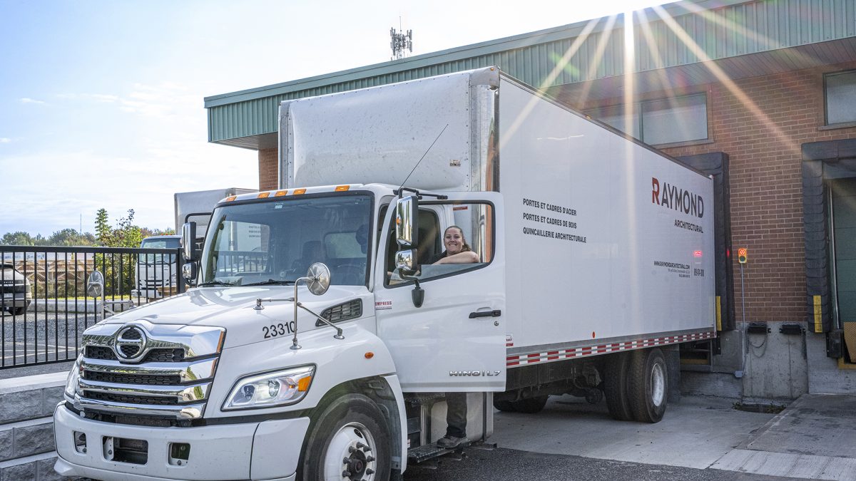Camion de livraison Raymond Architectural au quai de chargement pour la distribution de portes, cadres et quincaillerie architecturale – Raymond Architectural